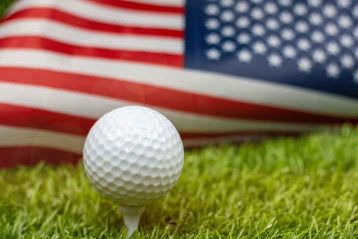 Golf Ball on Tee Against USA Flag