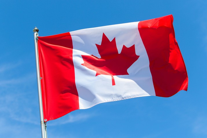 Canadian Flag Against Clear Blue Sky